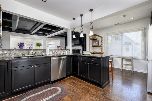 kitchen with a sink, dark cabinetry, dark wood-type flooring, a breakfast bar, and stainless steel dishwasher