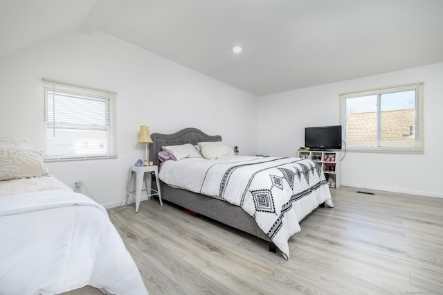 bedroom with baseboards, wood finished floors, multiple windows, and vaulted ceiling with beams