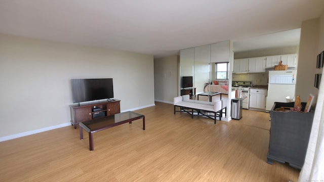 living area featuring light wood-style flooring and baseboards