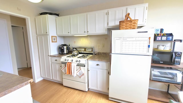 kitchen featuring decorative backsplash, white cabinetry, light wood-style floors, and white appliances