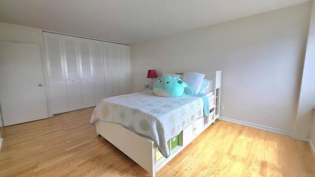 bedroom featuring light wood-style floors, a closet, and baseboards