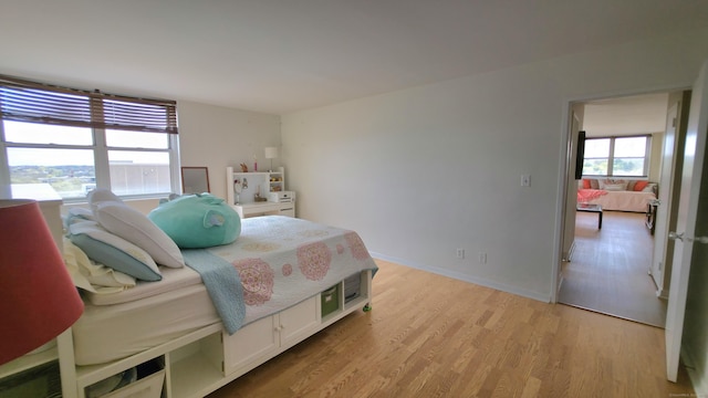 bedroom with light wood-style flooring and baseboards