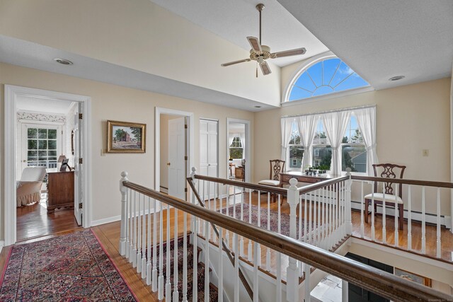 9 Academy Ln, Old Lyme, CT 06371 - hallway featuring an upstairs landing, wood finished floors, lofted ceiling, and baseboard heating