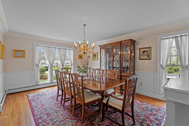 9 Academy Ln, Old Lyme, CT 06371 - dining space with a chandelier, light wood-type flooring, crown molding, wainscoting, and a textured ceiling
