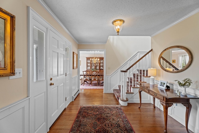 9 Academy Ln, Old Lyme, CT 06371 - entrance foyer with a chandelier, crown molding, stairway, a baseboard heating unit, and wood finished floors