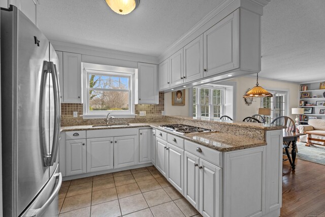 9 Academy Ln, Old Lyme, CT 06371 - kitchen with stainless steel appliances, plenty of natural light, a textured ceiling, and white cabinets