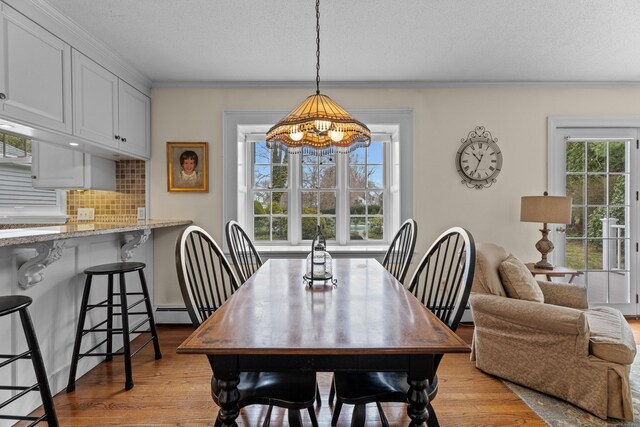 9 Academy Ln, Old Lyme, CT 06371 - dining room featuring healthy amount of natural light, crown molding, light wood-type flooring, a chandelier, and a textured ceiling