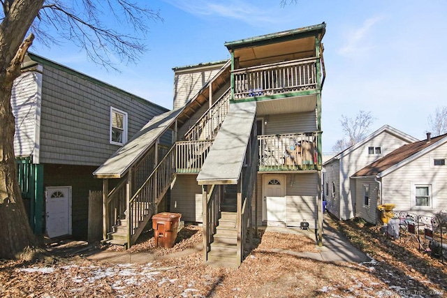 back of property featuring stairway, a deck, and a balcony