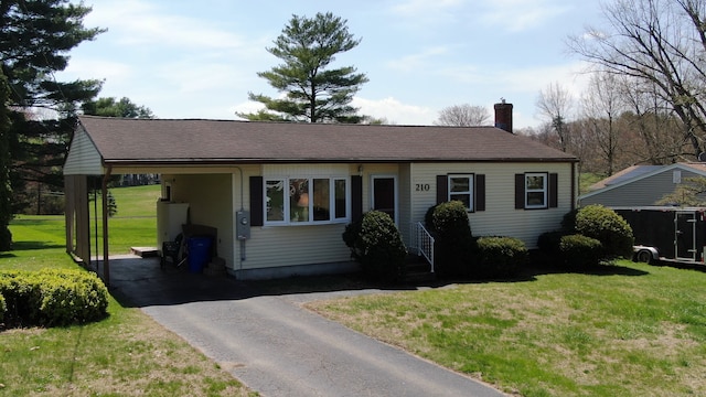 ranch-style house featuring a chimney, aphalt driveway, water heater, a front lawn, and an attached carport
