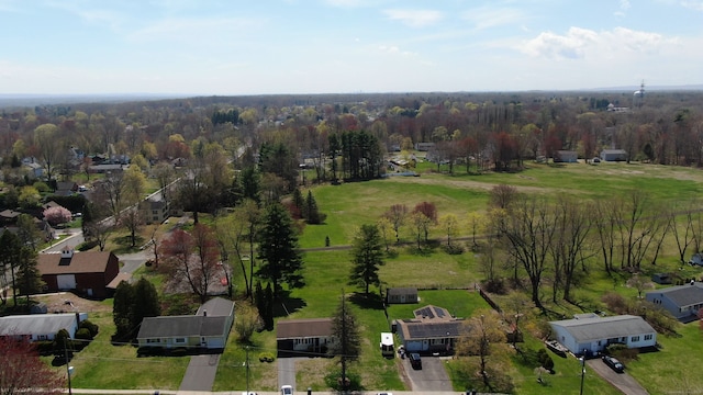 bird's eye view with a wooded view