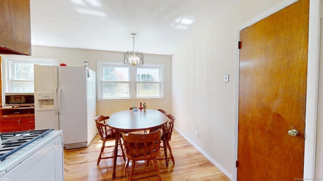 dining space featuring a notable chandelier and light wood finished floors