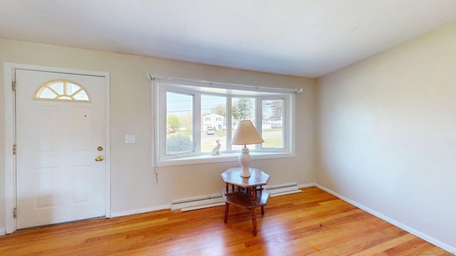 entrance foyer with baseboards, light wood-style flooring, and a baseboard heating unit