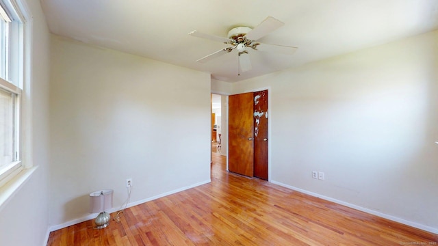 empty room featuring light wood-style floors, baseboards, and a ceiling fan
