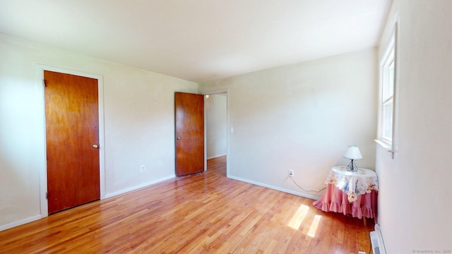 unfurnished bedroom featuring baseboards and light wood finished floors