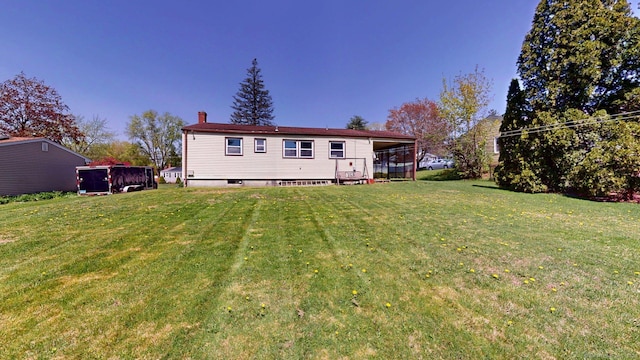 rear view of house with a chimney and a yard