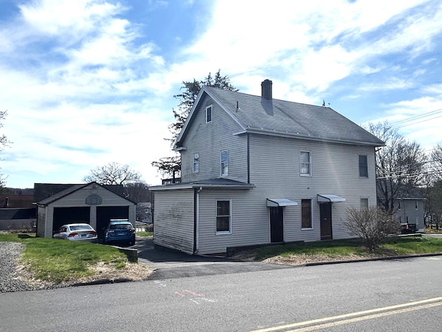 209 W Center St, Southington, CT 06489 - view of side of home featuring a garage, a chimney, and an outbuilding