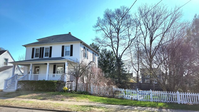view of front of property featuring a fenced front yard and covered porch