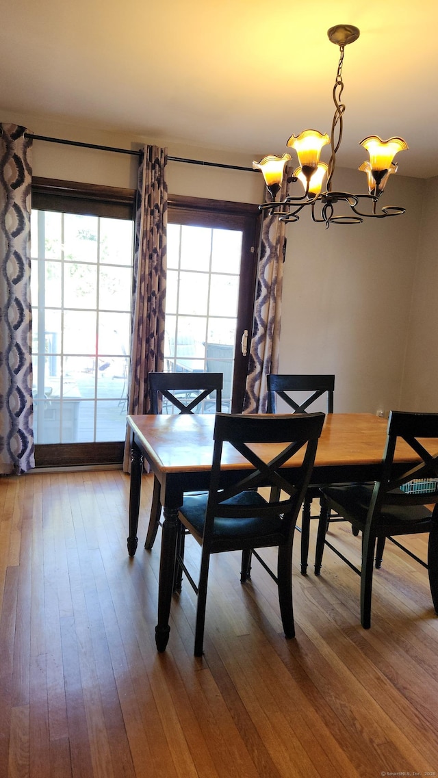 dining space featuring a wealth of natural light, a chandelier, and wood-type flooring