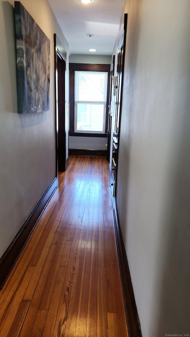 hall featuring dark wood finished floors and baseboards
