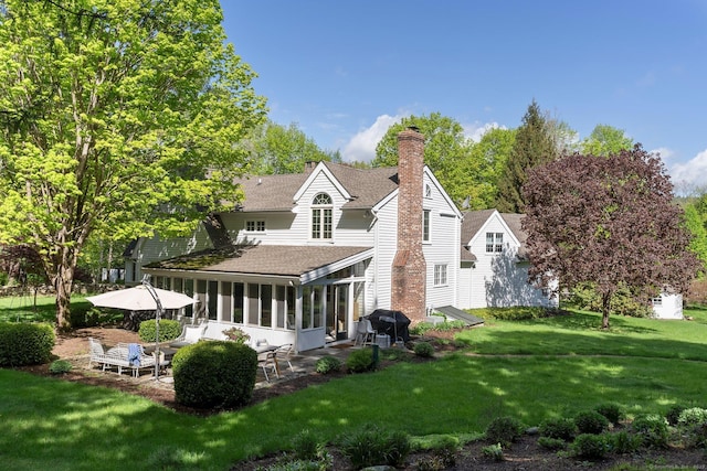 8 Twixt Rd, Cornwall, CT 06753 - back of house featuring a shingled roof, a sunroom, a chimney, a lawn, and a patio area