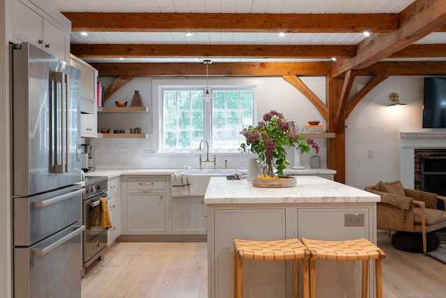 8 Twixt Rd, Cornwall, CT 06753 - kitchen featuring appliances with stainless steel finishes, light wood-style floors, a sink, a kitchen island, and backsplash