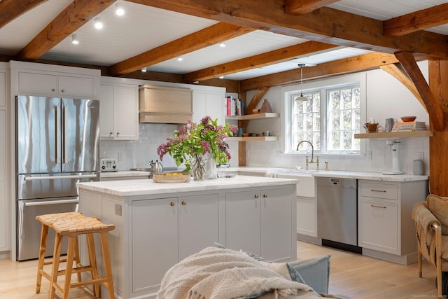 8 Twixt Rd, Cornwall, CT 06753 - kitchen with stainless steel appliances, open shelves, light wood finished floors, a center island, and decorative backsplash