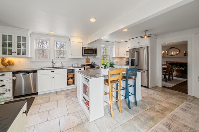 329 Weekeepeemee Rd, Woodbury, CT 06798 - kitchen featuring a breakfast bar area, white cabinetry, stainless steel appliances, decorative backsplash, and light stone counters