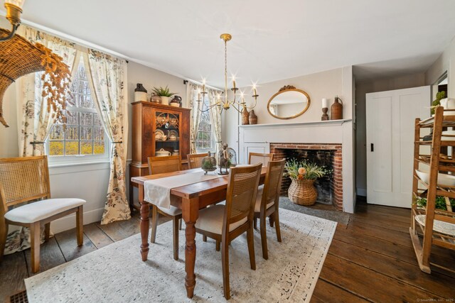 329 Weekeepeemee Rd, Woodbury, CT 06798 - dining space with baseboards, a brick fireplace, a chandelier, and hardwood / wood-style flooring