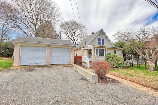 view of front of home featuring a front yard and a detached garage
