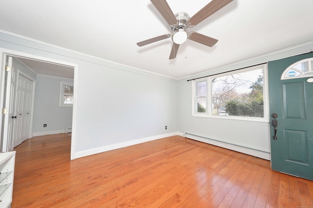foyer with light wood-style floors, crown molding, a ceiling fan, a baseboard heating unit, and baseboards