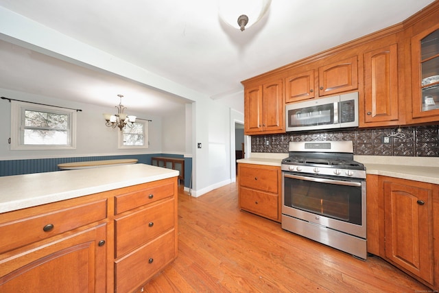 kitchen with brown cabinetry, appliances with stainless steel finishes, decorative backsplash, and light countertops