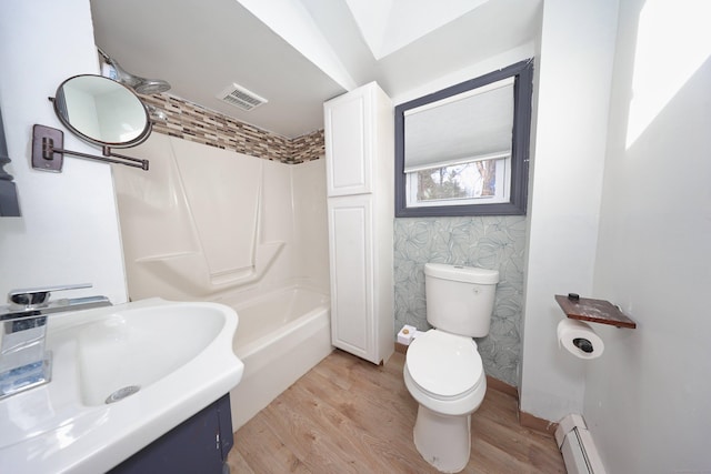 full bath with toilet, wood finished floors, baseboard heating, and visible vents