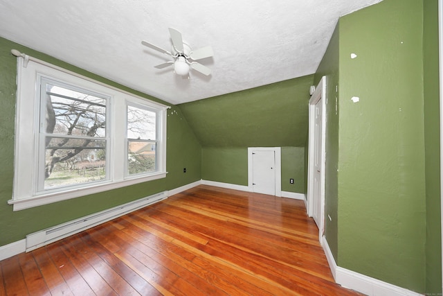 bonus room with ceiling fan, hardwood / wood-style floors, lofted ceiling, a baseboard radiator, and baseboards
