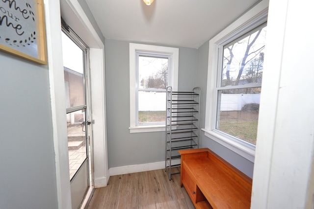 doorway to outside with light wood finished floors and baseboards