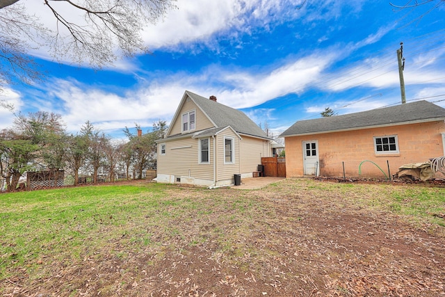 back of house with fence and a lawn