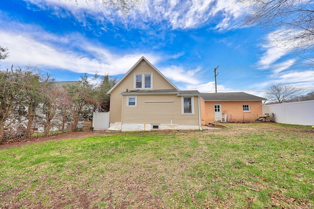 back of property featuring a yard and fence