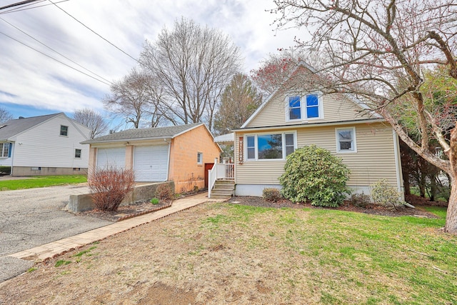 view of front of house featuring an outbuilding, a detached garage, and a front yard