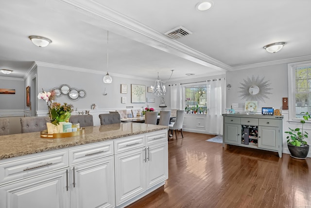 kitchen featuring a wealth of natural light, crown molding, and white cabinetry