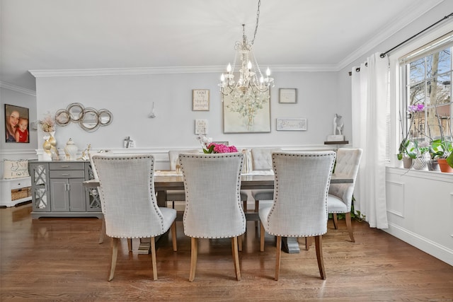 dining area featuring dark wood-type flooring, crown molding, and an inviting chandelier