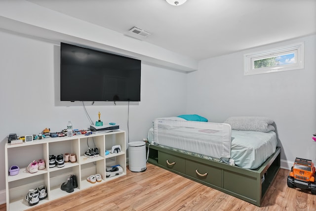 bedroom featuring visible vents, baseboards, and wood finished floors