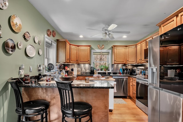 98 Aetna Ave, Torrington, CT 06790 - kitchen featuring a breakfast bar, ceiling fan, a peninsula, tasteful backsplash, and appliances with stainless steel finishes