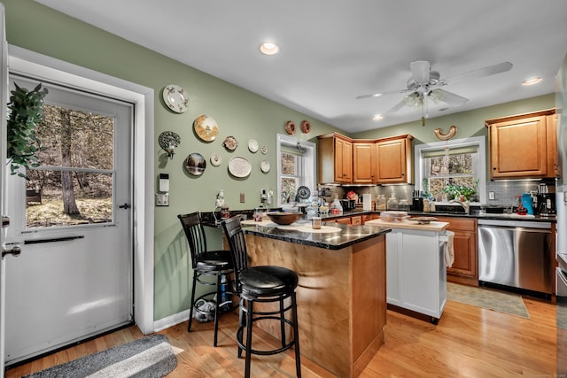 98 Aetna Ave, Torrington, CT 06790 - kitchen with stainless steel dishwasher, tasteful backsplash, a healthy amount of sunlight, and a breakfast bar