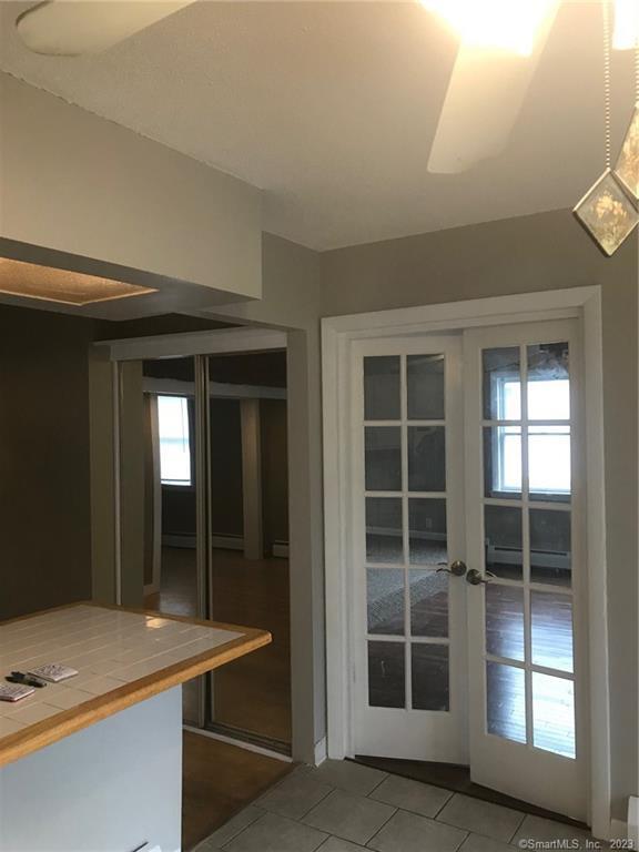 doorway featuring tile patterned flooring, french doors, and a baseboard radiator