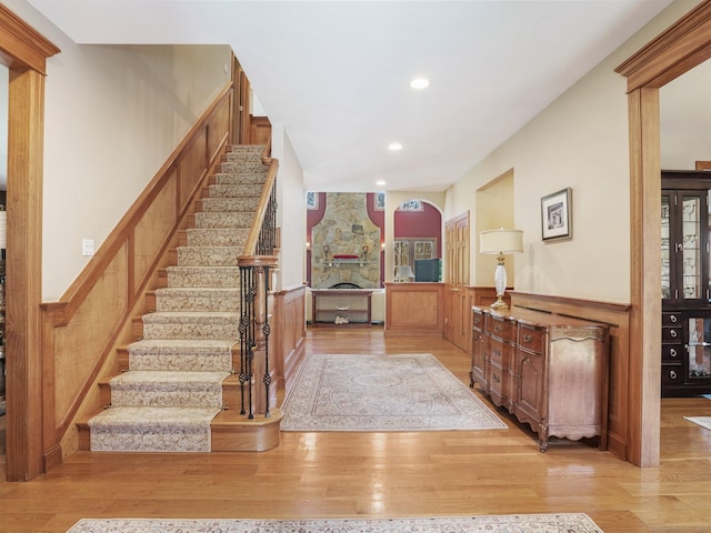 17 Fire Hill Ln, Redding, CT 06896 - entryway featuring wainscoting, stairway, wood finished floors, a stone fireplace, and recessed lighting
