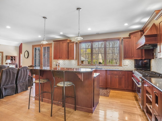 17 Fire Hill Ln, Redding, CT 06896 - kitchen with range with two ovens, open floor plan, a sink, light wood-style floors, and dark stone counters