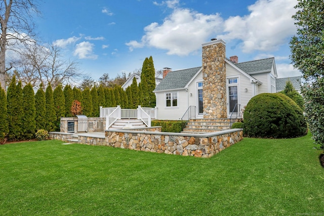 13 Bryan Rd, Norwalk, CT 06853 - back of house with a lawn, roof with shingles, and a chimney