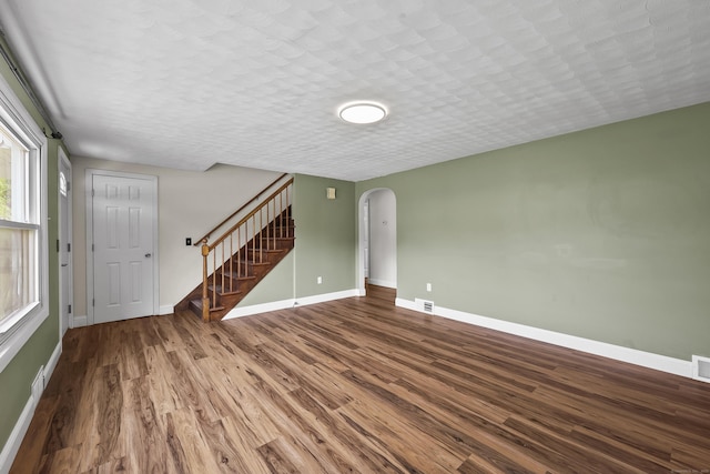 33 Jolley Rd, Plainfield, CT 06239 - unfurnished living room with arched walkways, wood finished floors, stairway, and baseboards