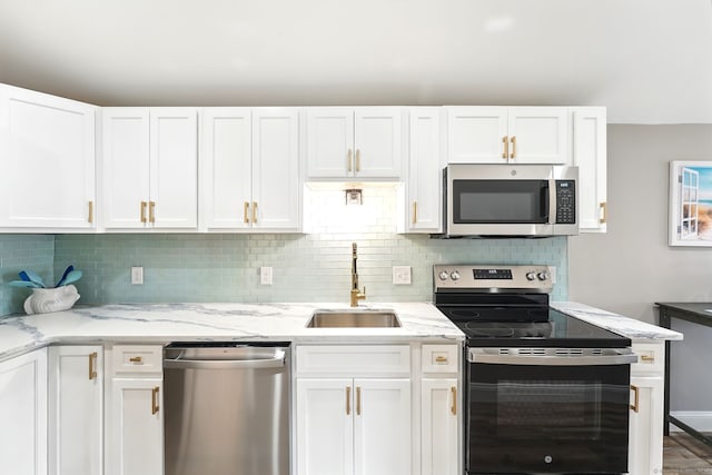 27 Prospect Ave, East Lyme, CT 06357 - kitchen featuring appliances with stainless steel finishes, a sink, white cabinets, and backsplash