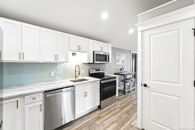 27 Prospect Ave, East Lyme, CT 06357 - kitchen featuring appliances with stainless steel finishes, a sink, white cabinetry, tasteful backsplash, and recessed lighting