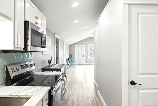27 Prospect Ave, East Lyme, CT 06357 - kitchen with appliances with stainless steel finishes, light wood finished floors, lofted ceiling, light stone countertops, and white cabinetry